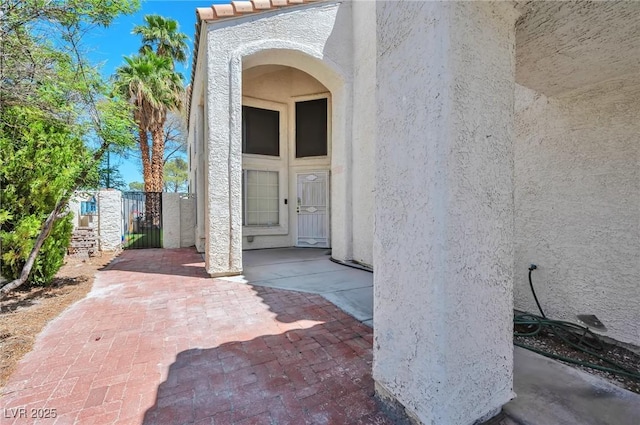 8404 Shore Breeze Dr, Las Vegas, NV 89128 - view of exterior entry with stucco siding, fence, and a gate