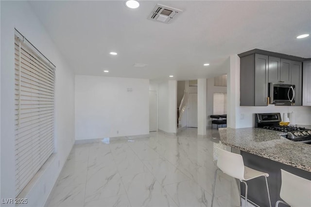 8404 Shore Breeze Dr, Las Vegas, NV 89128 - kitchen featuring appliances with stainless steel finishes, recessed lighting, baseboards, light marble finish floors, and light stone countertops