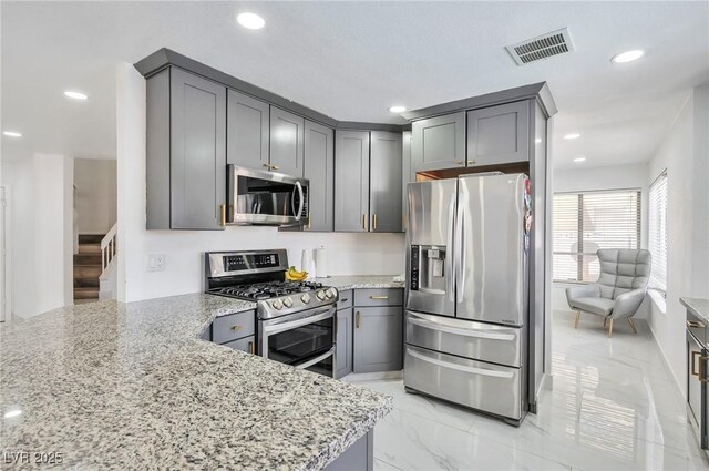 8404 Shore Breeze Dr, Las Vegas, NV 89128 - kitchen featuring appliances with stainless steel finishes, light stone countertops, recessed lighting, light marble finish floors, and gray cabinets