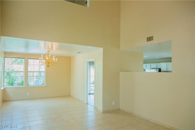 7840 Millhopper Ave, Las Vegas, NV 89128 - unfurnished room featuring a chandelier, a high ceiling, light tile patterned floors, and baseboards