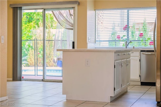 7840 Millhopper Ave, Las Vegas, NV 89128 - kitchen featuring dishwasher, white cabinets, light tile patterned floors, and light countertops