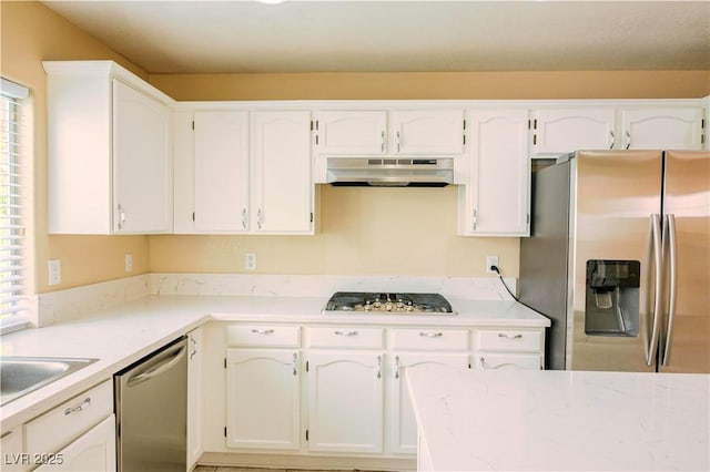 7840 Millhopper Ave, Las Vegas, NV 89128 - kitchen featuring appliances with stainless steel finishes, under cabinet range hood, white cabinetry, light stone countertops, and a sink
