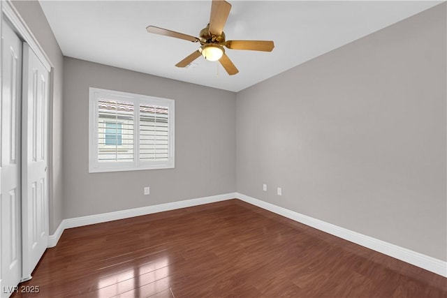 unfurnished bedroom featuring baseboards, a closet, a ceiling fan, and wood finished floors