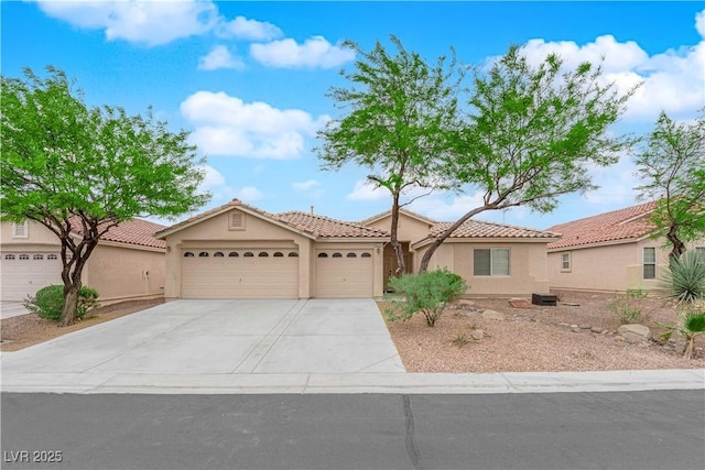 mediterranean / spanish-style home featuring an attached garage, stucco siding, a tiled roof, and driveway