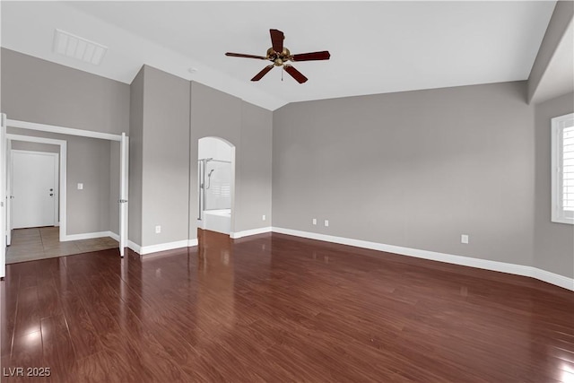 unfurnished living room featuring arched walkways, a ceiling fan, visible vents, and wood finished floors