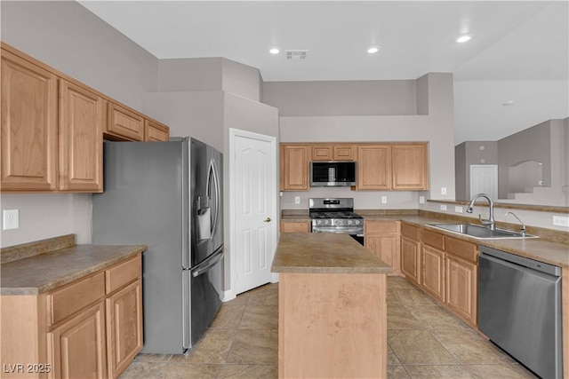 kitchen with a sink, visible vents, light brown cabinetry, a kitchen island, and appliances with stainless steel finishes