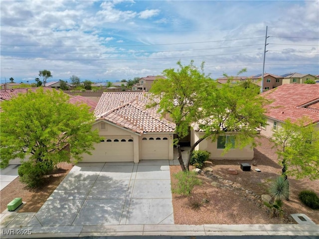mediterranean / spanish-style home featuring a residential view, a garage, stucco siding, a tile roof, and driveway
