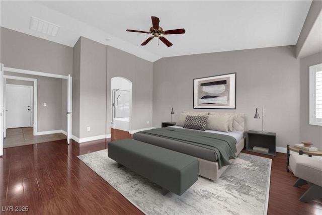 bedroom featuring arched walkways, baseboards, visible vents, and dark wood-style floors