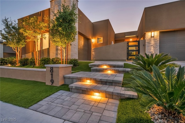819 Bolide St, Las Vegas, NV 89138 - view of front facade featuring an attached garage, stone siding, and stucco siding