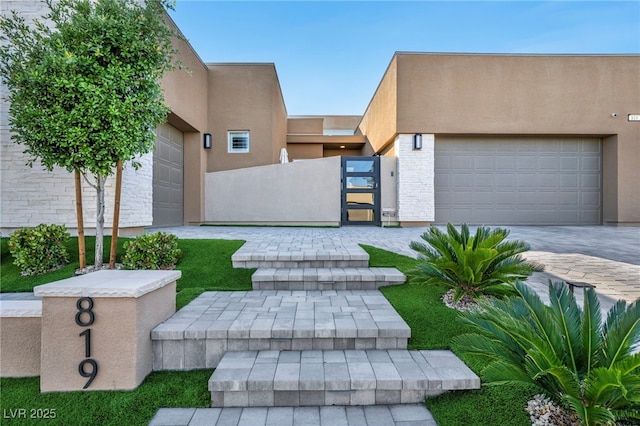 819 Bolide St, Las Vegas, NV 89138 - view of front of house featuring an attached garage, a gate, stucco siding, fence, and driveway