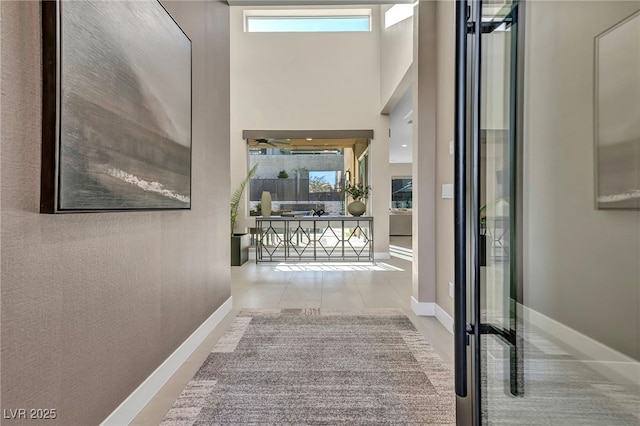 819 Bolide St, Las Vegas, NV 89138 - hallway with plenty of natural light, baseboards, a high ceiling, and tile patterned floors