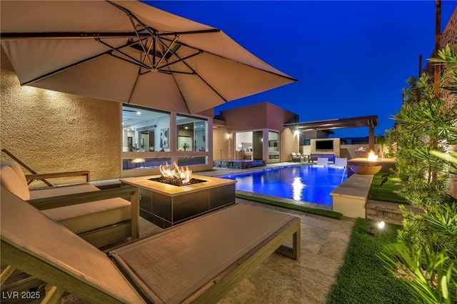819 Bolide St, Las Vegas, NV 89138 - pool at night featuring an outdoor fire pit, a patio, and an outdoor pool