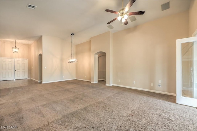 8664 Frasure Falls Ave, Las Vegas, NV 89178 - carpeted empty room with ceiling fan with notable chandelier, visible vents, baseboards, arched walkways, and vaulted ceiling