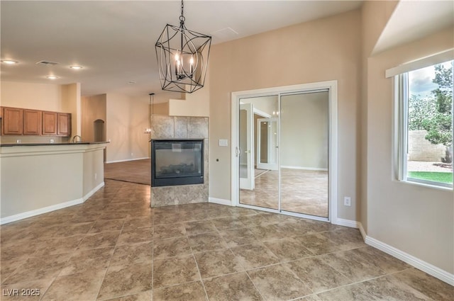 8664 Frasure Falls Ave, Las Vegas, NV 89178 - unfurnished living room featuring a chandelier, a wealth of natural light, baseboards, and recessed lighting