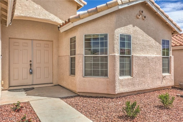 8664 Frasure Falls Ave, Las Vegas, NV 89178 - view of exterior entry with stucco siding and a tile roof