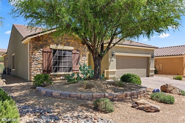 single story home featuring driveway, a garage, stucco siding, a tile roof, and stone siding