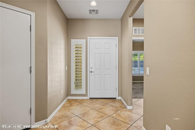 entrance foyer featuring baseboards, light tile patterned floors, and visible vents