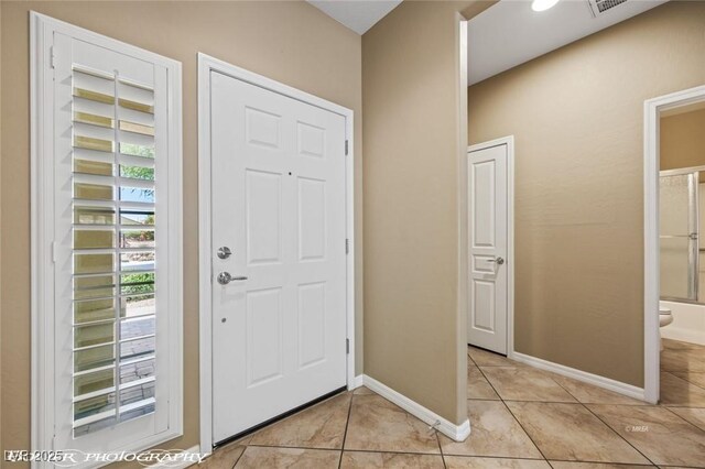 entryway featuring light tile patterned floors and baseboards