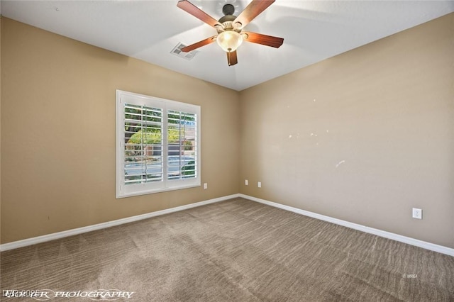 carpeted spare room featuring visible vents, baseboards, and ceiling fan