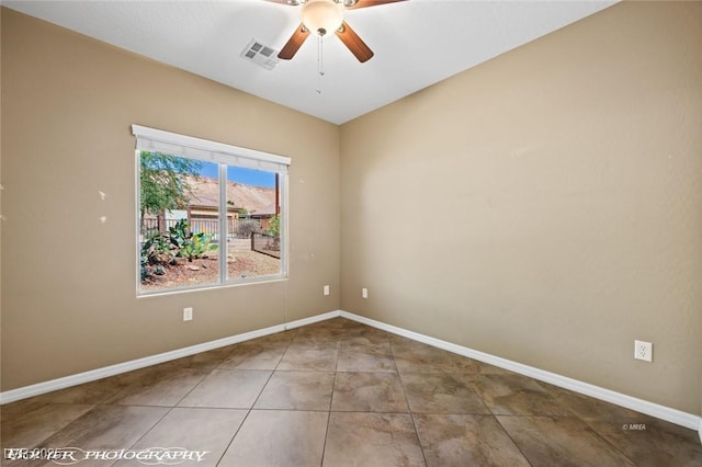 tiled empty room featuring visible vents, baseboards, and a ceiling fan