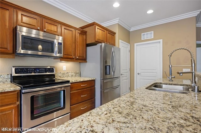 kitchen with a sink, brown cabinets, visible vents, light stone countertops, and appliances with stainless steel finishes
