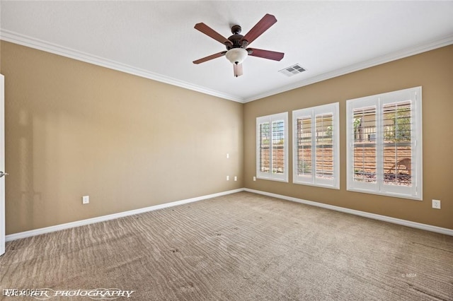 empty room featuring a ceiling fan, ornamental molding, visible vents, and baseboards