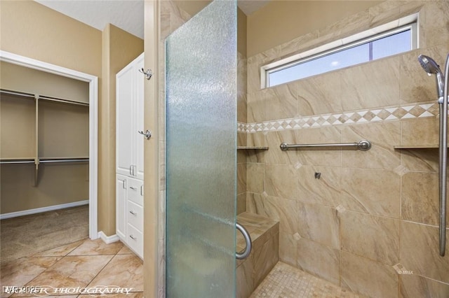 full bath with a tile shower and a spacious closet