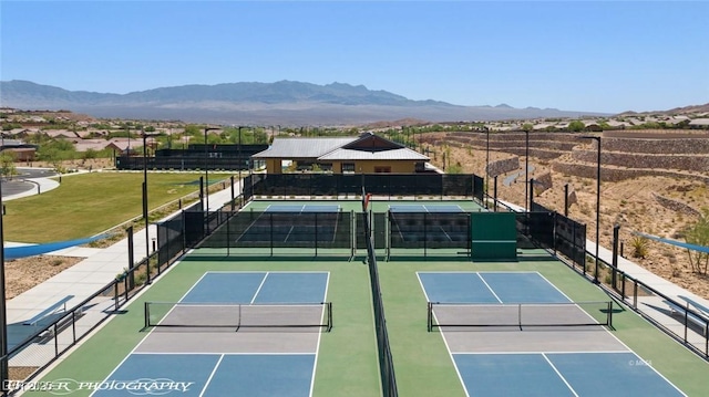 view of tennis court with a mountain view, fence, and community basketball court