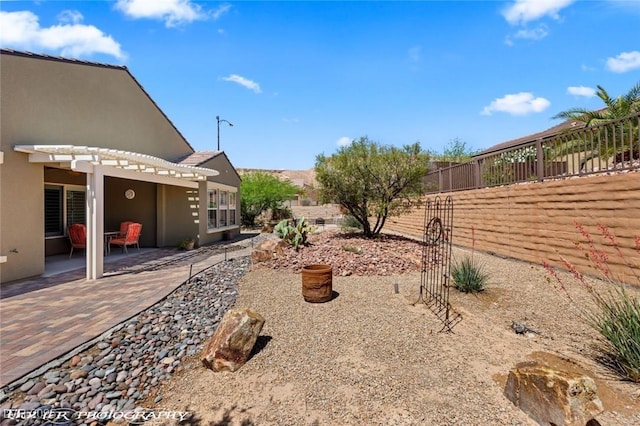 view of yard with a pergola, fence, and a patio area