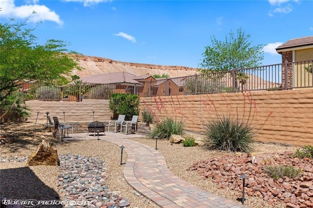 view of yard with an outdoor fire pit, a patio, a mountain view, and a fenced backyard