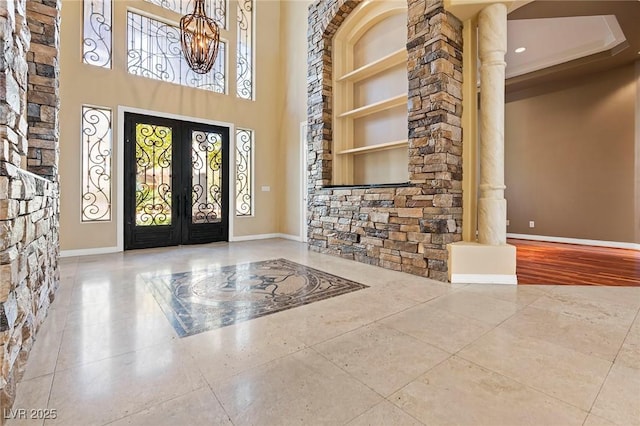1008 Trophy Hills Dr, Las Vegas, NV 89134 - tiled entryway with a notable chandelier, french doors, baseboards, a towering ceiling, and ornate columns