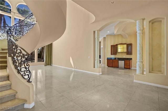 1008 Trophy Hills Dr, Las Vegas, NV 89134 - unfurnished living room featuring arched walkways, stairs, baseboards, and recessed lighting