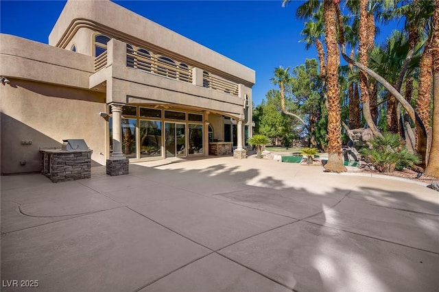 1008 Trophy Hills Dr, Las Vegas, NV 89134 - rear view of house featuring exterior kitchen, a patio area, stucco siding, and a balcony
