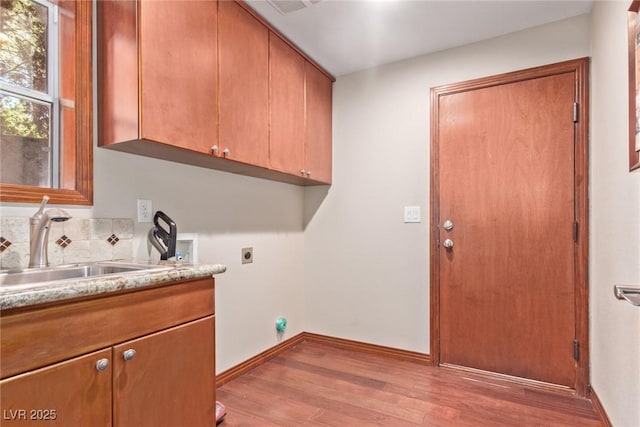 1008 Trophy Hills Dr, Las Vegas, NV 89134 - washroom with light wood-style flooring, a sink, cabinet space, electric dryer hookup, and hookup for a washing machine