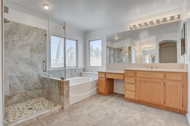 full bathroom featuring a shower stall, a garden tub, and vanity