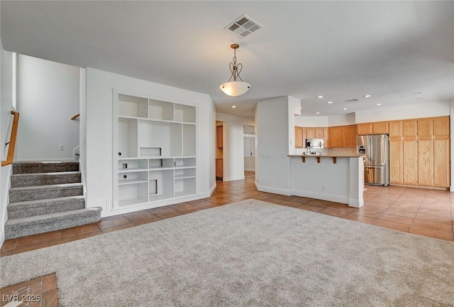 unfurnished living room with light tile patterned floors, recessed lighting, visible vents, and built in shelves