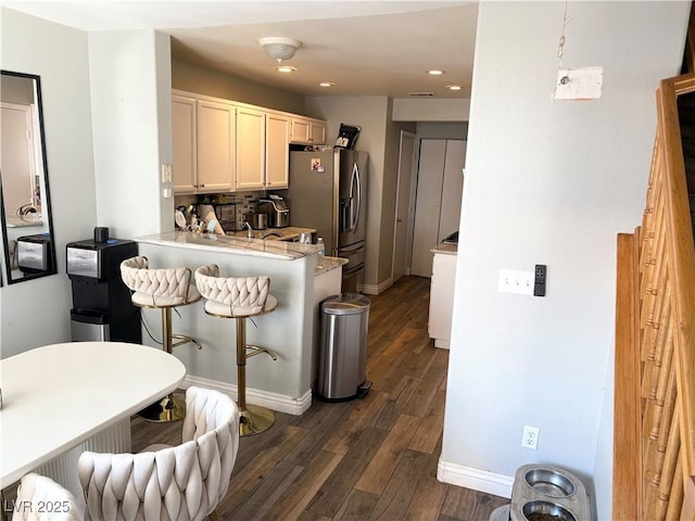 5024 Starfinder Ave, Las Vegas, NV 89108 - kitchen with light countertops, a breakfast bar, dark wood-style floors, white cabinets, and recessed lighting