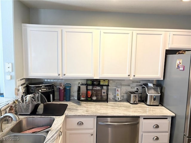 5024 Starfinder Ave, Las Vegas, NV 89108 - kitchen with appliances with stainless steel finishes, white cabinets, a sink, backsplash, and light stone counters