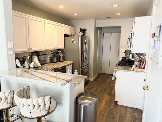 5024 Starfinder Ave, Las Vegas, NV 89108 - kitchen featuring appliances with stainless steel finishes, a peninsula, recessed lighting, dark wood-type flooring, and a breakfast bar