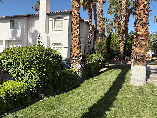 5024 Starfinder Ave, Las Vegas, NV 89108 - view of side of property with stucco siding, a tile roof, and a yard