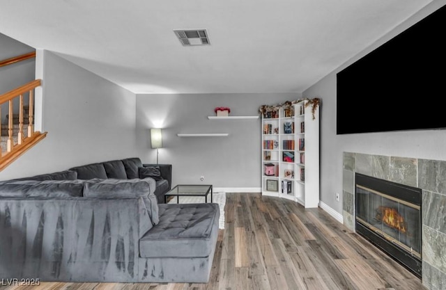 5024 Starfinder Ave, Las Vegas, NV 89108 - living area with a fireplace, wood finished floors, stairs, and baseboards