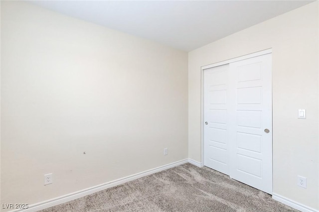 unfurnished bedroom with light colored carpet, baseboards, and a closet