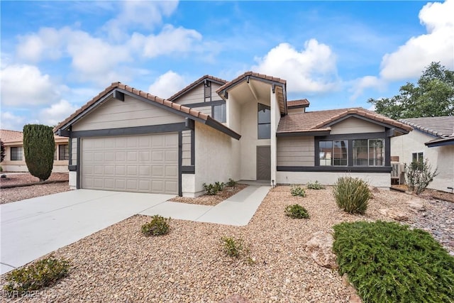 view of front of property featuring concrete driveway, stucco siding, a tile roof, and a garage