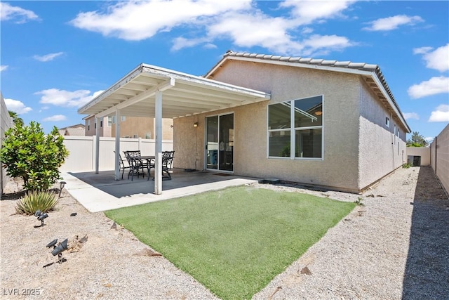 back of house with stucco siding and a patio