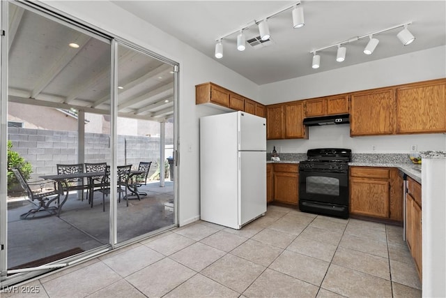 kitchen featuring freestanding refrigerator, black range with gas stovetop, under cabinet range hood, and brown cabinets