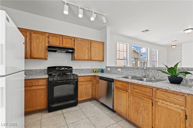 kitchen with black gas stove, freestanding refrigerator, dishwasher, a sink, and under cabinet range hood