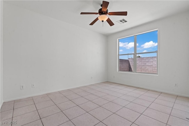 empty room featuring a ceiling fan, light tile patterned floors, and baseboards