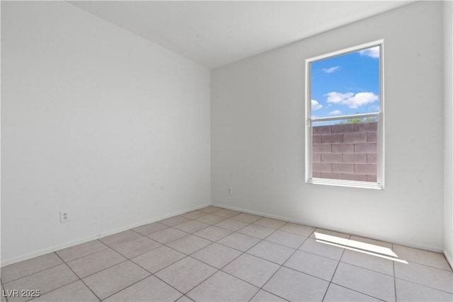 unfurnished room with light tile patterned flooring and baseboards