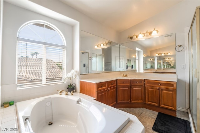 bathroom with a stall shower, lofted ceiling, tile patterned flooring, a garden tub, and vanity