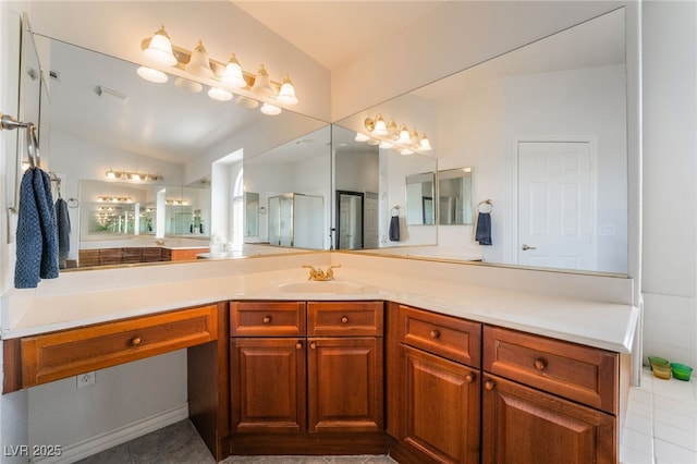 full bathroom featuring a shower with door, vanity, lofted ceiling, and tile patterned floors
